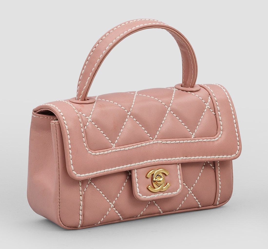 "Top-Handle Flap Bag" von CHANEL: Roséfarbenes Kalbsleder in charakteristischer Rautensteppung mit weißen Nähten, weißem Innenfutter und vergoldeter Hardware. Rechteckiger Korpus mit CC-Logo Drehverschluss und gerundetem Griff. Gr