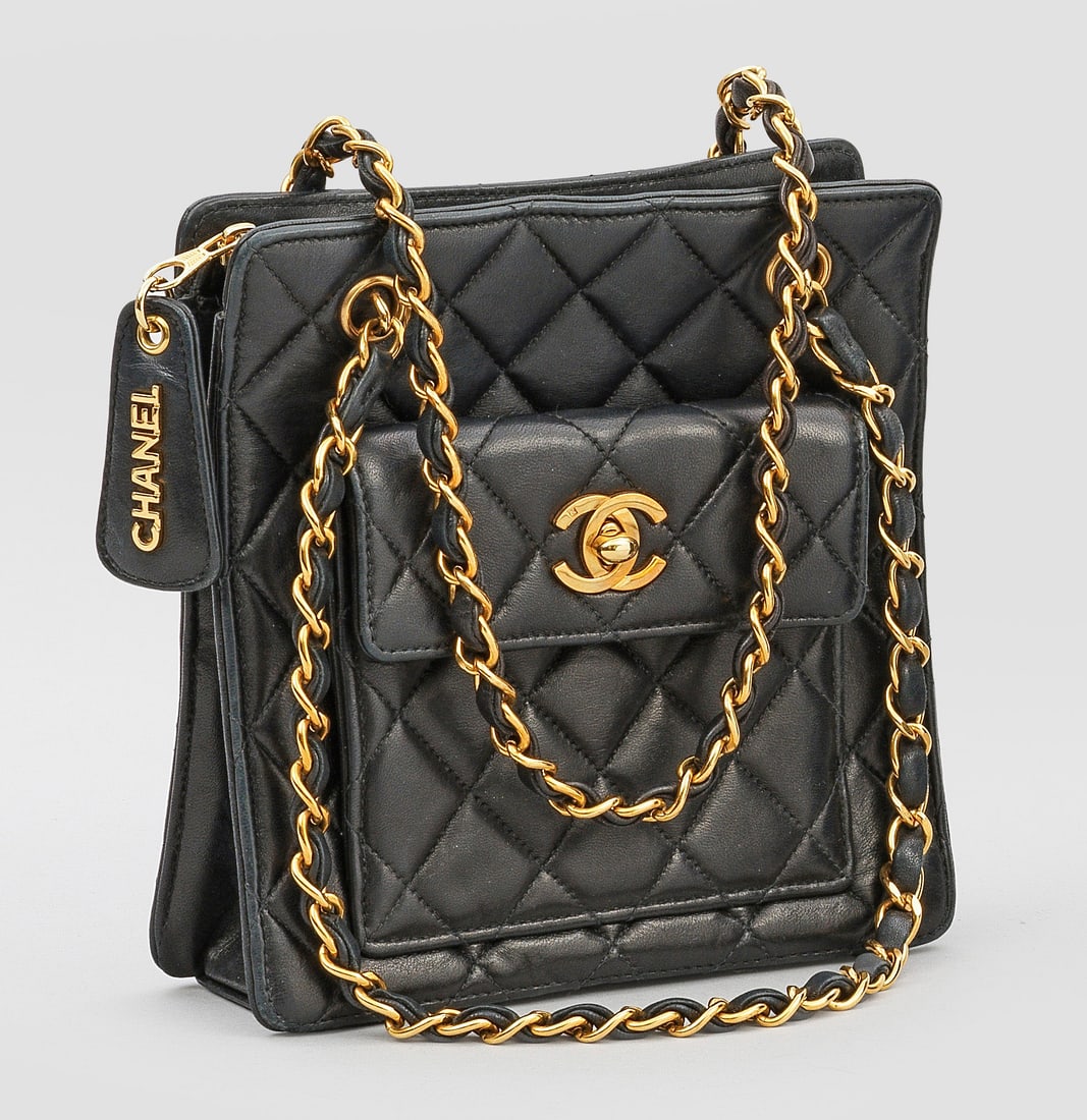 Vintage Chanel-Tasche: Schwarzes Lammleder in charakteristischer Rautensteppung und vergoldete Hardware. Rechteckiger leicht konischer Korpus mit CC-Logo Drehverschluss an der kleinen Fronttasche. Rückseitige Stecktasche u
