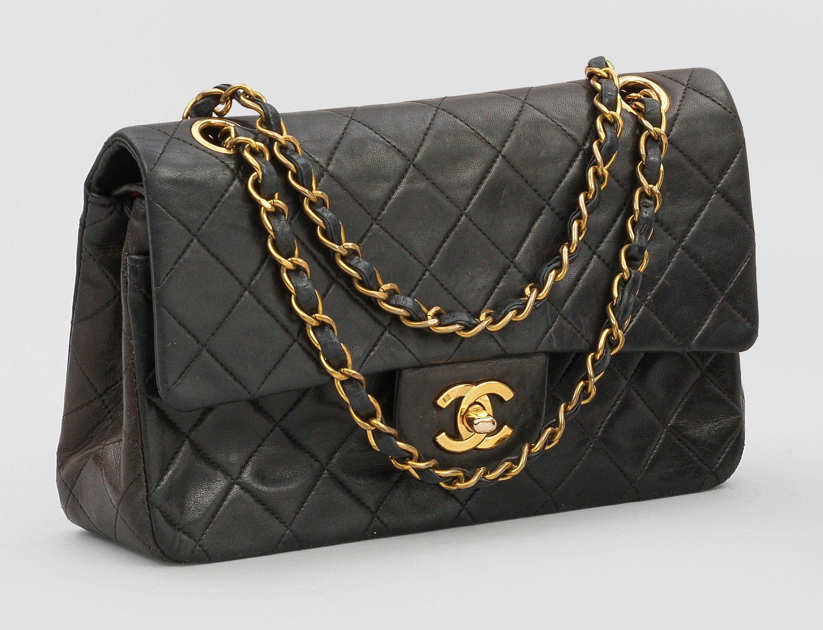 "Timeless Flap Bag" von CHANEL: Schwarzes, bzw. bordeauxrotes Lammleder in charakteristischer Rautensteppung und vergoldete Hardware. Rechteckiger leicht konischer Korpus mit CC-Logo Drehverschluss. Großes Innenfach mit zwei Seiten