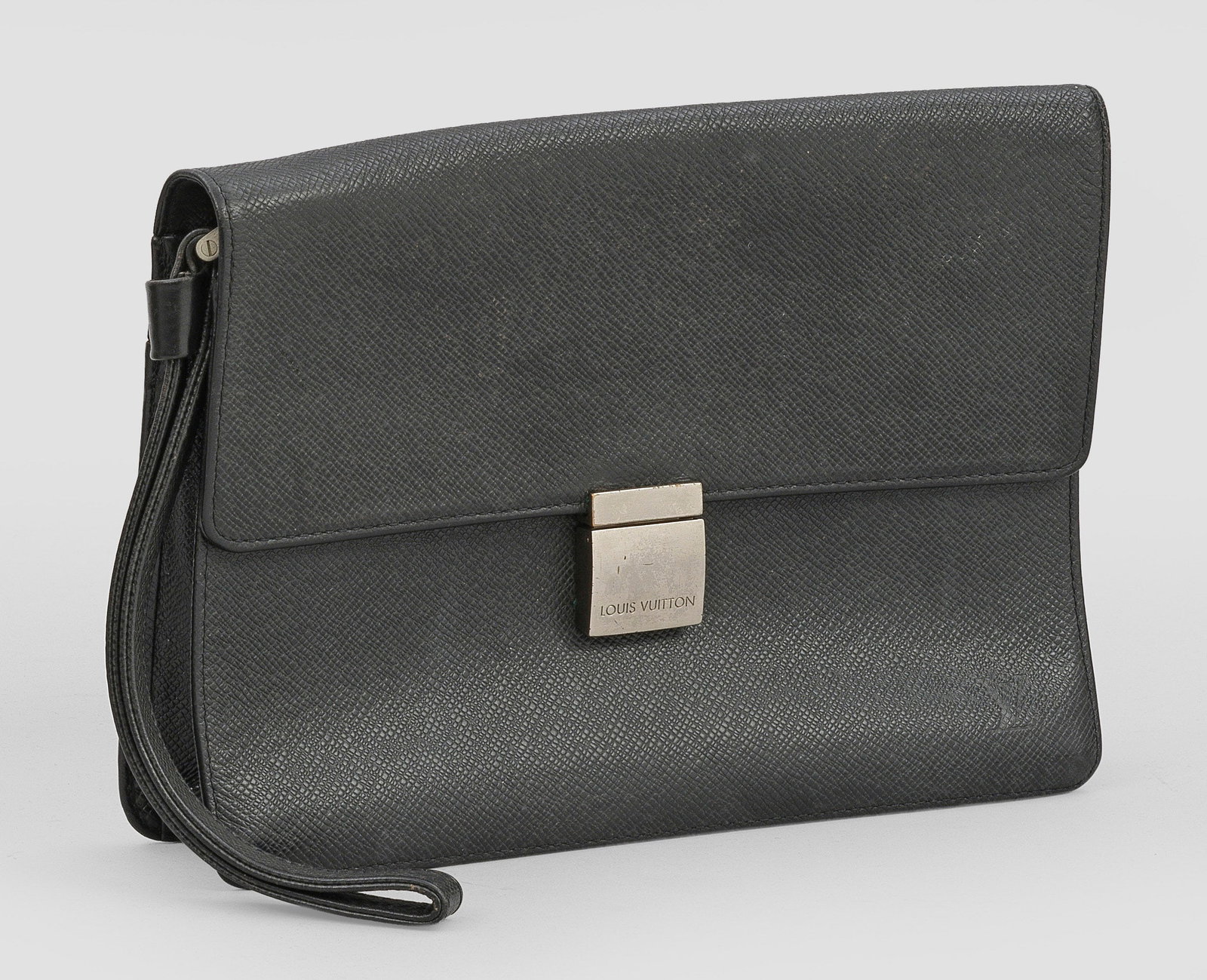 Vintage-Clutch "Taiga Selenga" von LOUIS VUITTON: Anthrazitfarbenes Leder und silberfarbene Hardware. Rechteckiger Korpus mit seitlicher Halteschlinge und zentralem Verschluss. Herstellerzeichen. Data Code: CA0072. H. 18,5 cm. 26 cm x 6,5 cm. A Vinta