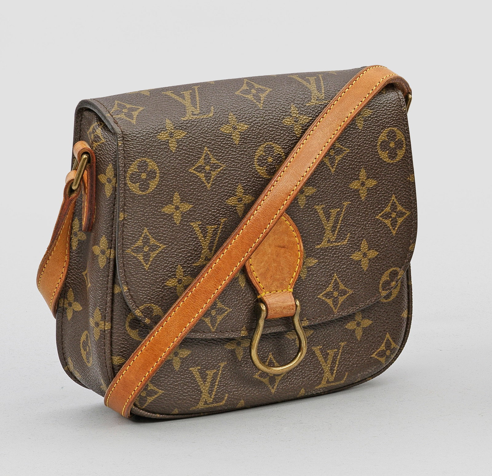 Vintage-Umhängetasche "Saint Cloud" von LOUIS VUITTON: Monogram-Canvas und helles Leder mit gelben Nähten. Rechteckiger, leicht konischer Korpus mit gerundeten Ecken, mittig mit hufeisenförmigem Ring besetztem Überschlagdeckel und längenverstellbarem 