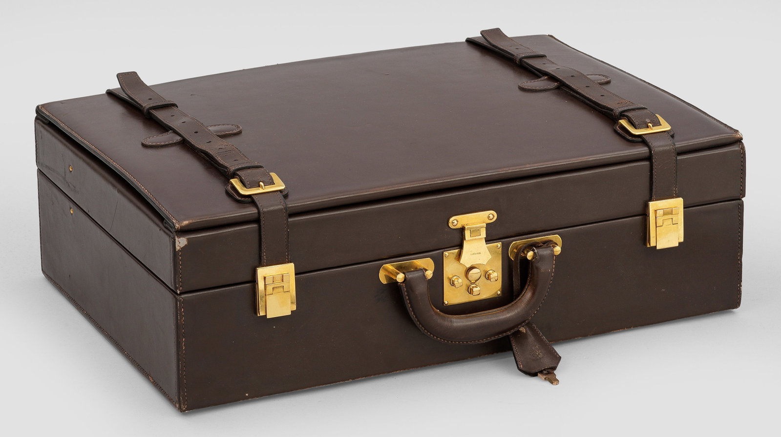 Seltener Vintage-Aktenkoffer von HERMÈS: Walnussbraunes Leder. Vergoldete Hardware. Gerader, rechteckiger Korpus mit gerundeter Handhabe, zwei Schnürgurten und abschließbarer Mittelschließe. Innen im Deckel 7-gliedriges Fächerregister mi