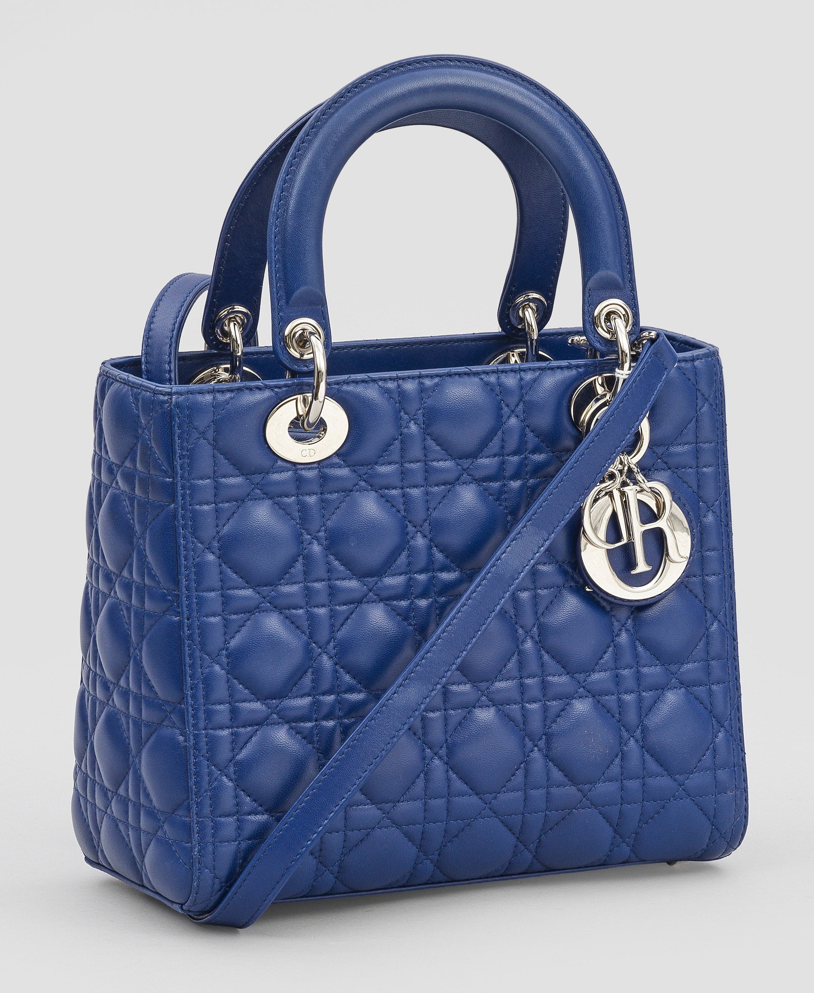 Medium "Lady Dior"-Handtasche: Blaues Kalbsleder mit sog. "Cannage"-Absteppung. Hardware mit Silber-Finish. Innen großes und kleines Fach. D.I.O.R Anhänger sowie abnehmbarer Trageriemen. Serien-Nr. 01-BO-1123. Hersteller-Logo sow