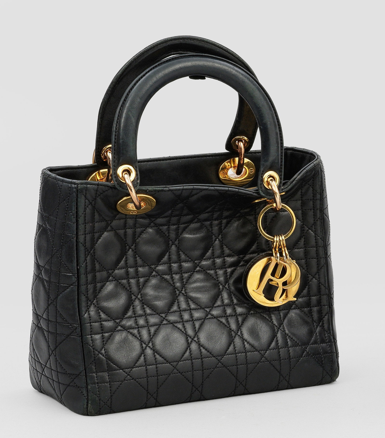 Vintage Handtasche "Lady DIOR Medium": Schwarzes Leder mit Cannage-Steppung und vergoldeter Hardware. Leicht konischer Korpus mit gerundeten Henkeln. Hauptfach und Innentasche mit Reißverschlüssen. Herstellerzeichen. Code: MA-0917. Stark