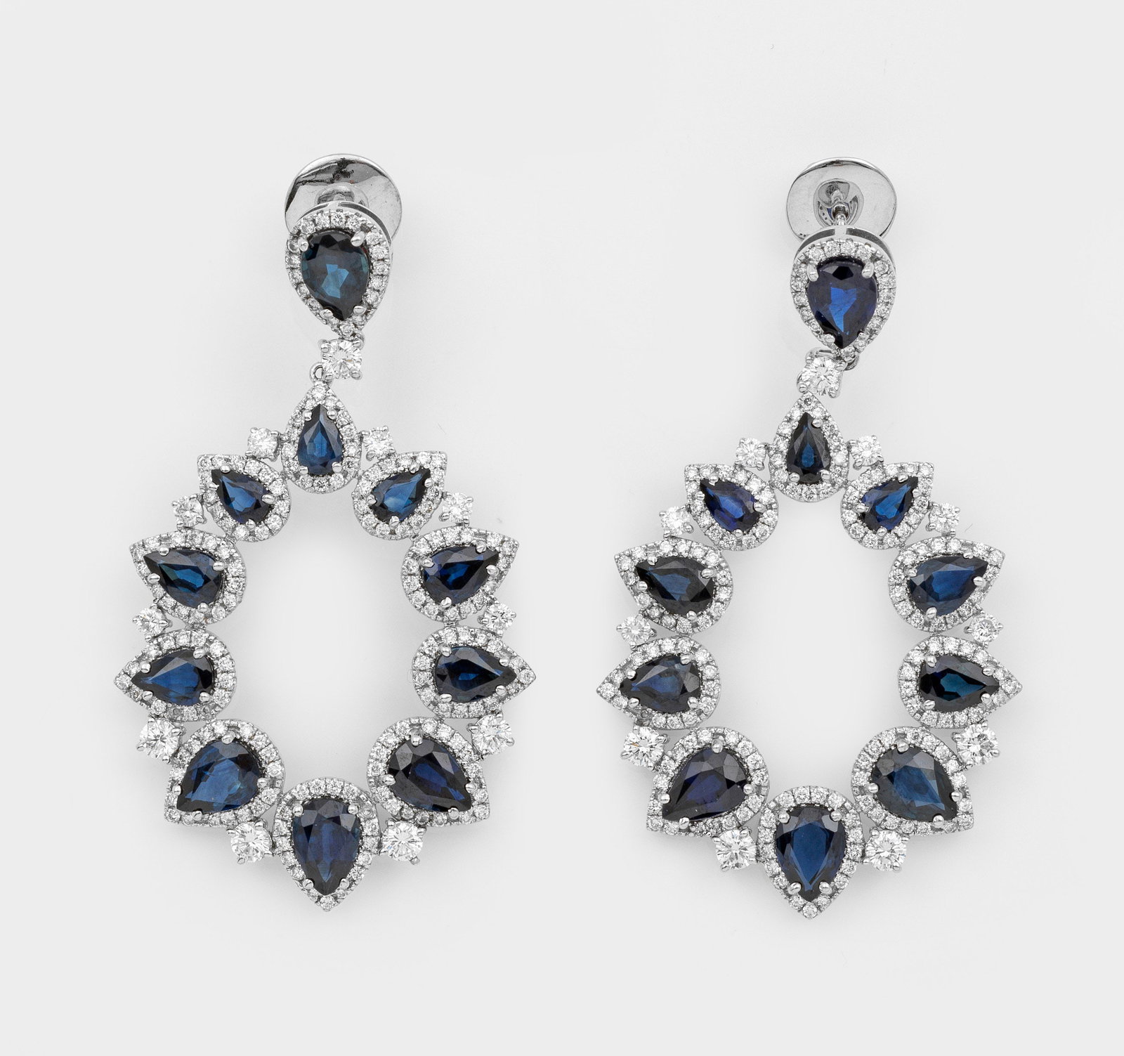 Prachtvolle Saphir-Brillant-Ohrgehänge: Weißgold, gest. 585. Oval angeordnete, Nachthimmel-blaue Saphirtropfen von zus. ca. 11,50 ct., entouriert mit Brillanten von zus. ca. 3,06 ct.; Gew. ca. 9,50 g. Pair of earrings set with night blue s