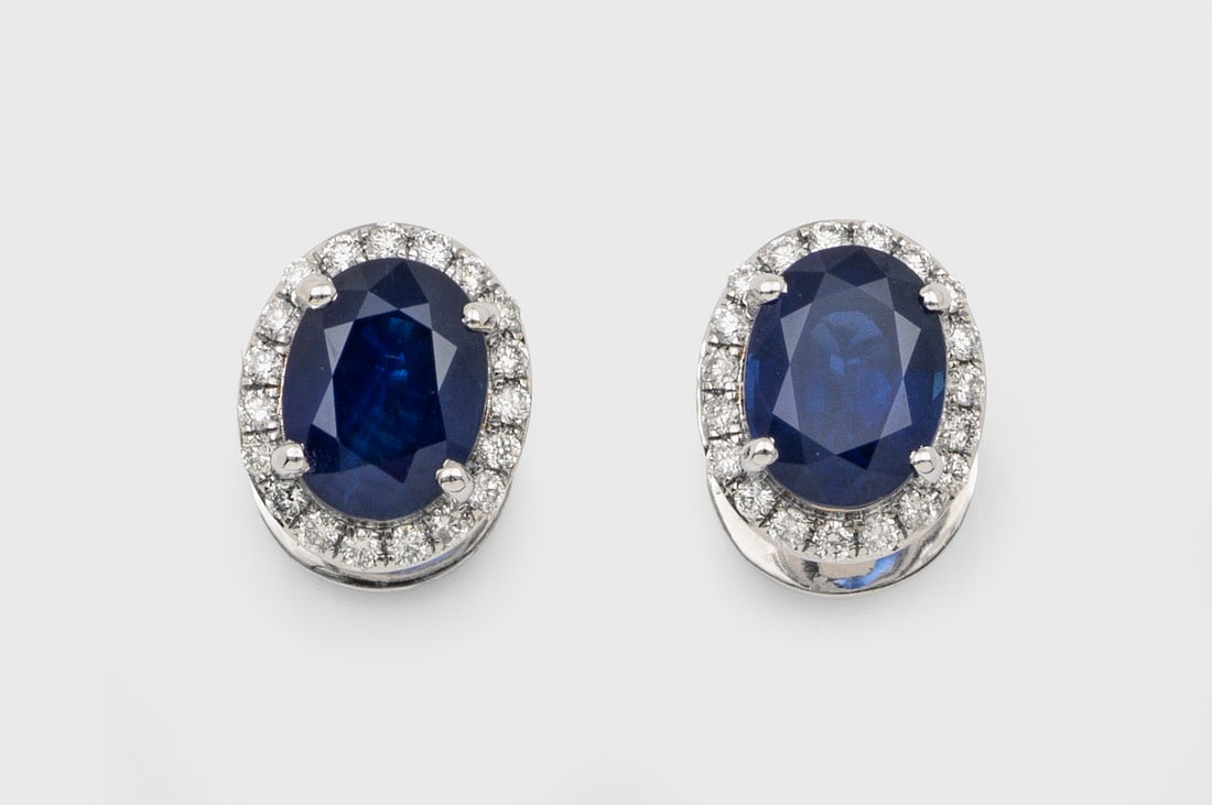 Paar Entourage-Saphir-Brillant-Ohrstecker: Weißgold, gest. 585. Zentral besetzt von 2 royalblauen Saphiren zus. ca. 3,84 ct., entouriert von Brillanten ca. 0,40 ct.; Gew. 4,80 g. Pair of earrings set with 2 sapphires approx. 3,84 ct. and diam
