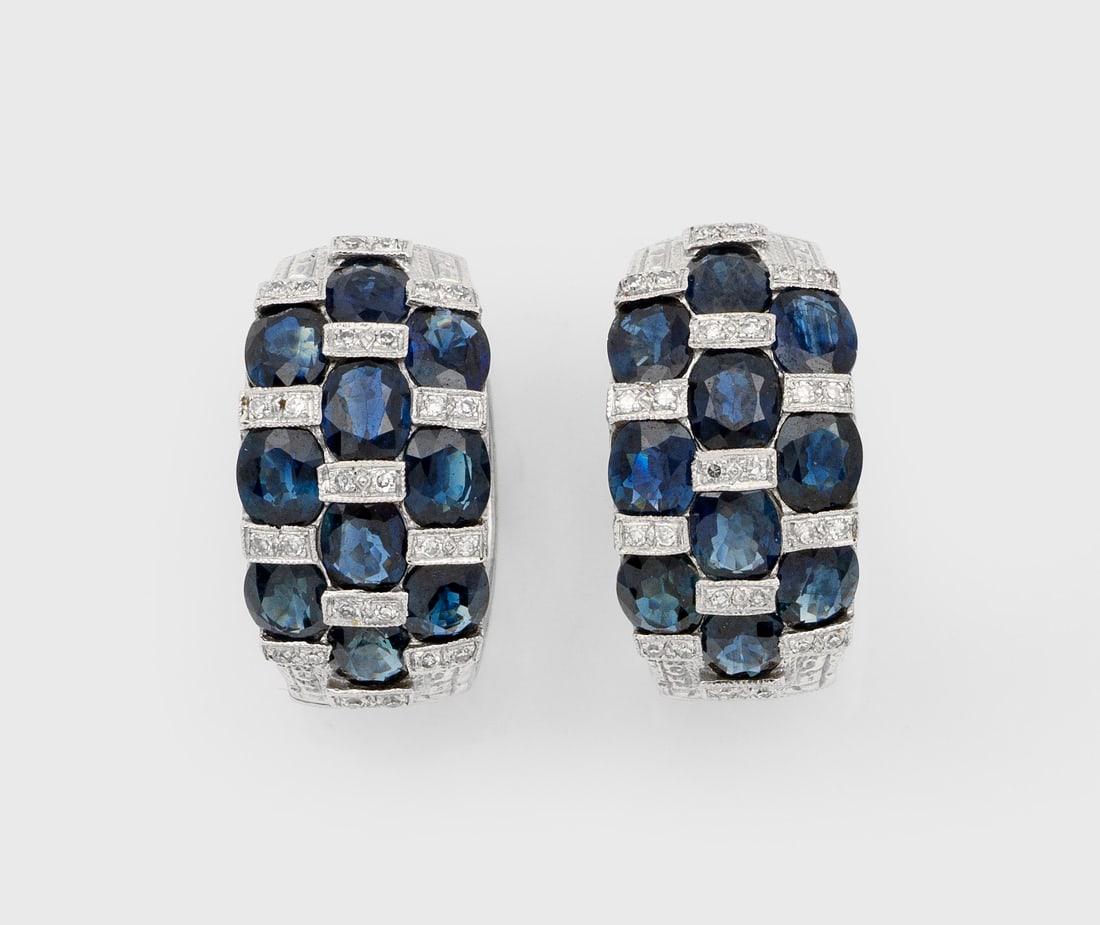 Paar klassische Saphir-Ohrclips: Weißgold, gest. 585 ct.; Schauseitig besetzt mit indigoblauen Saphiren von zus. ca. 5,00 ct., akzentuiert durch kleine Diamanten. Ges.-Gew. ca. 7,67 g. Pair of earrings set with sapphires approx. 5,0