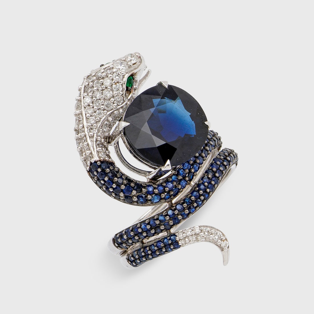 Extravaganter Schlangenring mit Saphir: Weißgold, gest. 750,. Plastisch gestaltet, ausgefasst mit Brillanten und Saphiren in Pavéfassung, akzentuiert durch royalblauen, unbehandelten Saphir von ca. 5,00 ct.; Gew. ca. 10,42 g. Beiliegend E