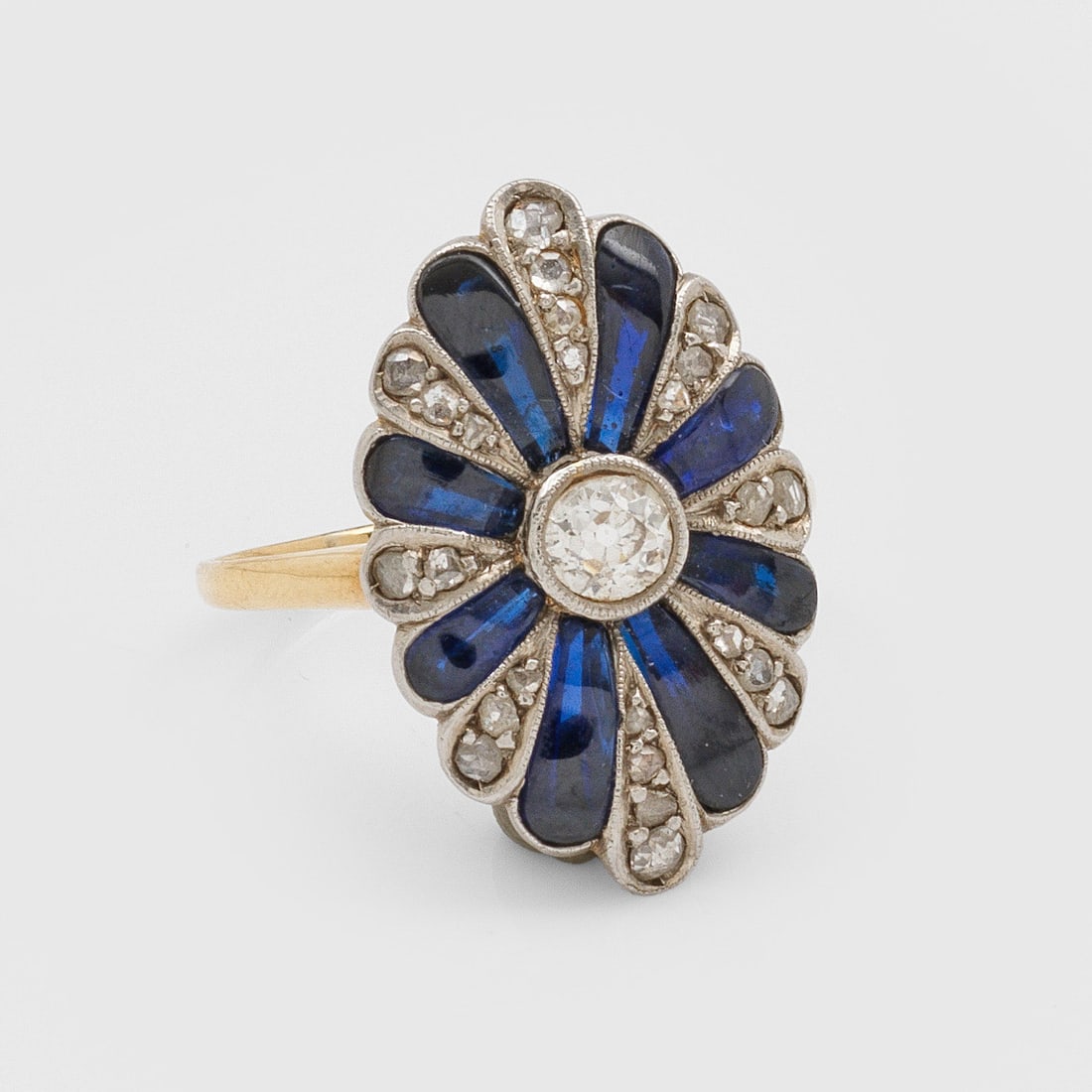 Jugendstil Marquise-Diamantring: Gelbgold, gest. 18 ct. Rosettenförmiger Ringkopf besetzt mit Altschliffdiamanten von zus. ca. 0,30 ct. und blauen Farbsteinen. Gew. ca. 3,75 g. Ring set with diamonds approx. 0,30 ct. and blue stones