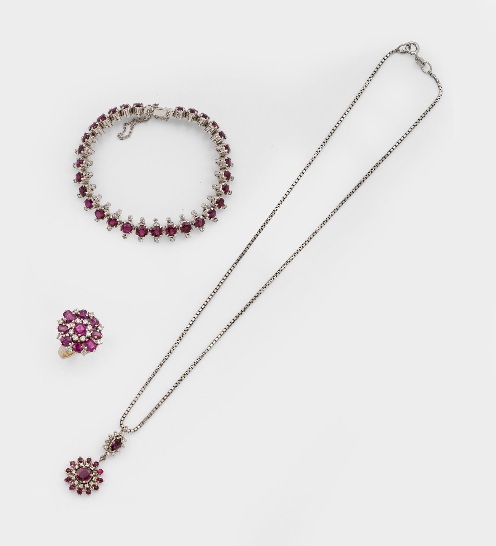 Klassisches Rubin-Diamant-Parure: Weißgold, gest. 585/18 ct.; Armband, korrespondierender Ring und Anhänger mit Milanesekette, schauseitig besetzt mit pinkfarbenen sowie tiefroten Rubinen von zus. ca. 6,00 ct.; Ges.-Gew. ca. 33,88 g