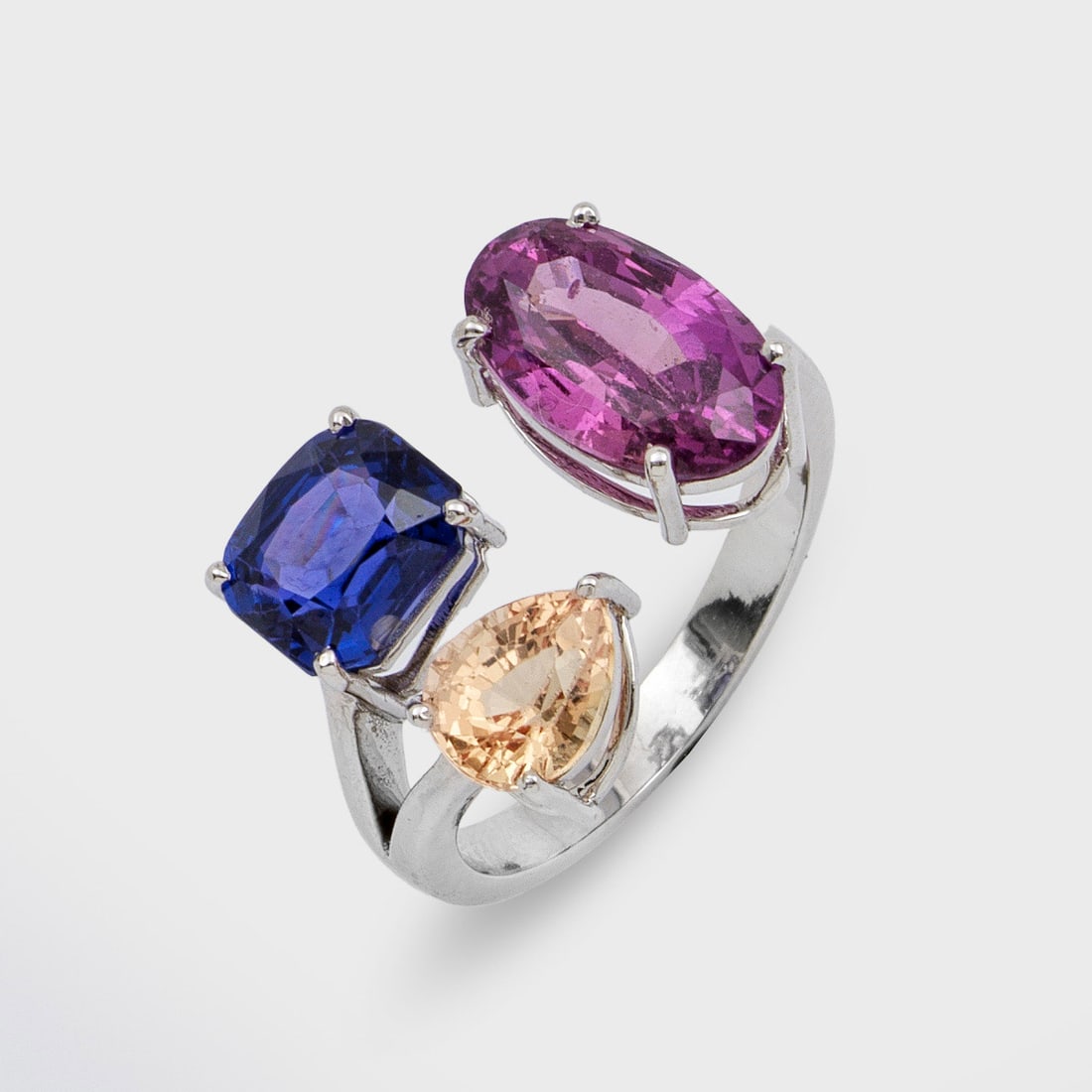 Moderner Multicolor-Saphir-Ring: Weißgold, gest. 585. Minimalistisch gestalteter Ring besetzt mit 3 Saphiren von ca. 3,22 ct, ca. 1,22 ct. und ca. 0,95 ct. in den Farben Pink, Gelb und Kornblumenblau. Gew. ca. 5 g. Ring set with a p