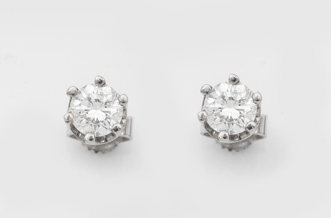 Paar klassische Brillantsolitär-Ohrringe: Weißgold, gest. 585. Zentral besetzt mit 2 Brillanten von jeweils 0,40 ct. (I-J/si). Ges.-Gew. ca. 2,35 g. Pair of earrings set with 2 brilliant solitaires each approx. 0,40 ct. (I-J/si), in 14 k whi
