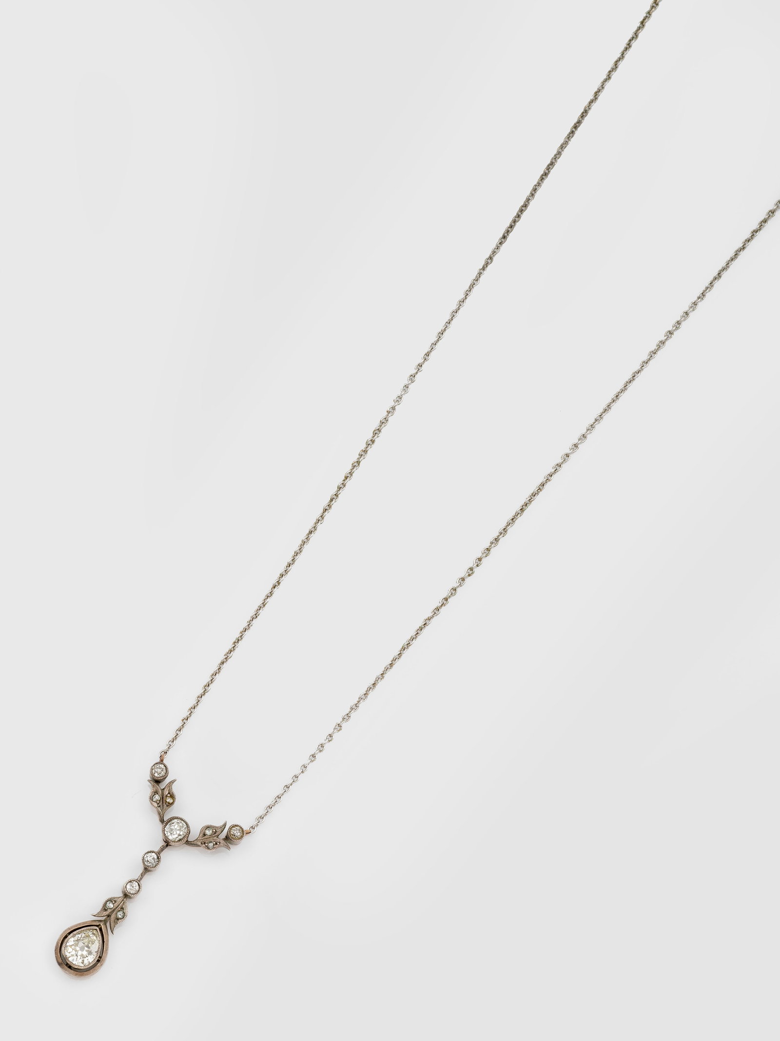 Jugendstil-Diamant-Lavalier-Collier: Platin und Roségold, 14 ct.; Floral gestalteter Anhänger besetzt mit Altschliffdiamanten von zus. ca. 1,00 ct., an feiner Gliederkette. Ges.-Gew. ca.4,49 g. Necklace set with diamonds approx. 1,00 c