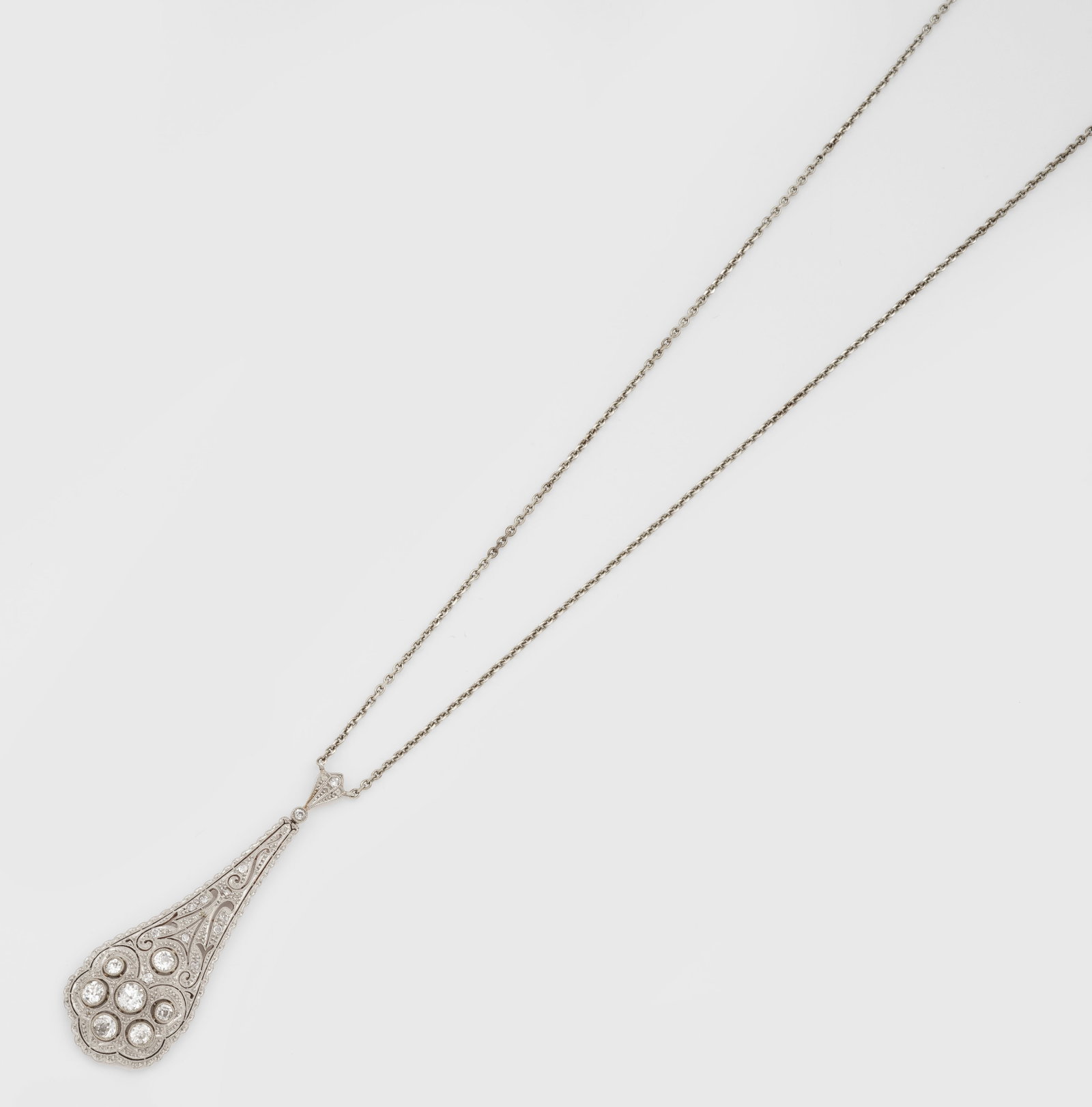 Jugendstil-Diamant-Collier: Gelbgold, 14 ct. und Platin. Pendeloque-Anhänger in ornamentaler Ajourarbeit, besetzt mit Altschliffdiamanten von zus. ca. 1,10 ct., an feiner Gliederkette. Ges.-Gew. ca. 12,10 g. Pendant set with di