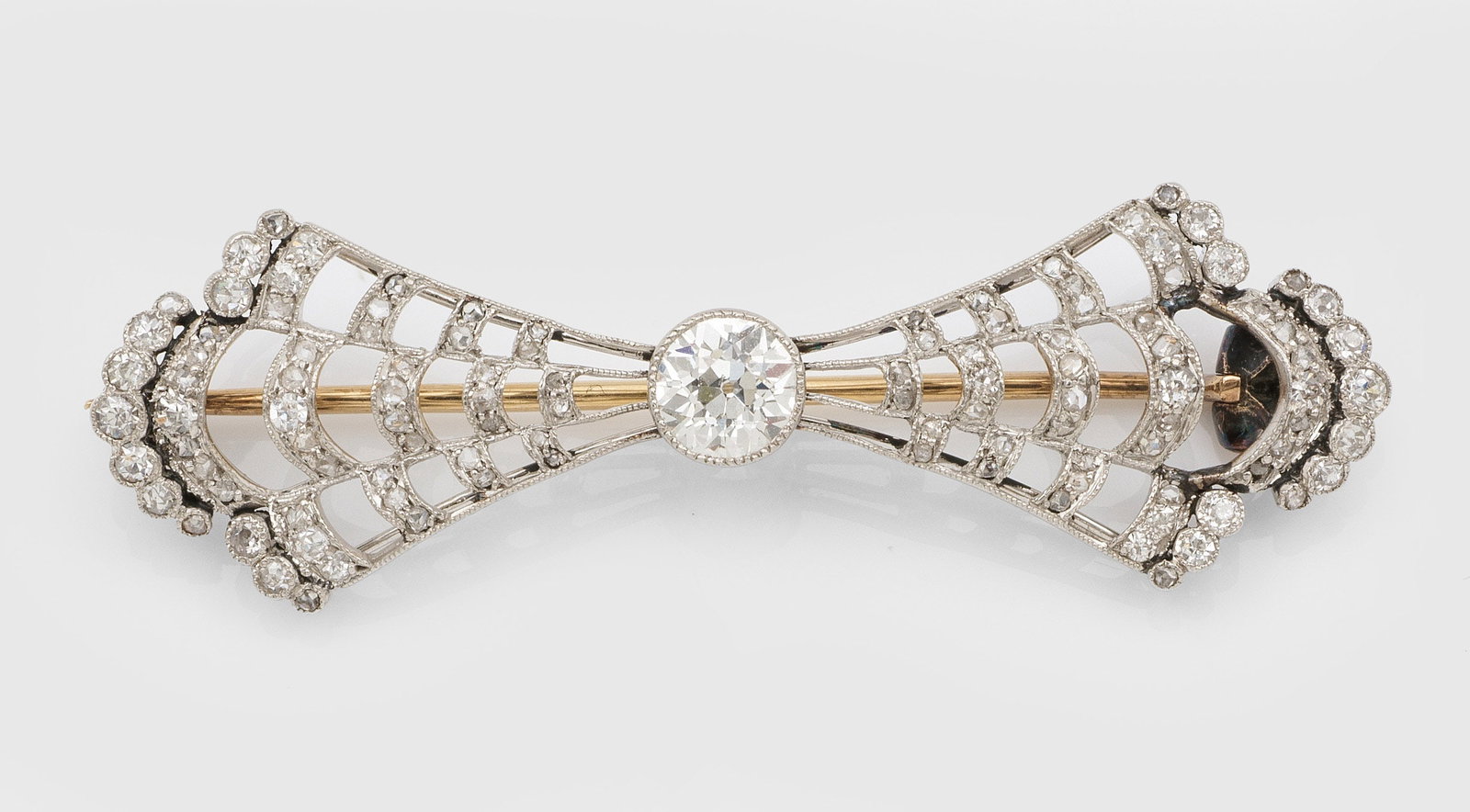 Jugendstil-Diamant-Brosche in Ajour: Platin. In stilisierter Schleifenform, zentral besetzt mit Altschliffdiamanten von ca. 0,50 ct. und kleinen Diamantrosen. Gew. ca. 4,96 g. Brooch set with diamond approx. 0,50 ct. and small diamond ro