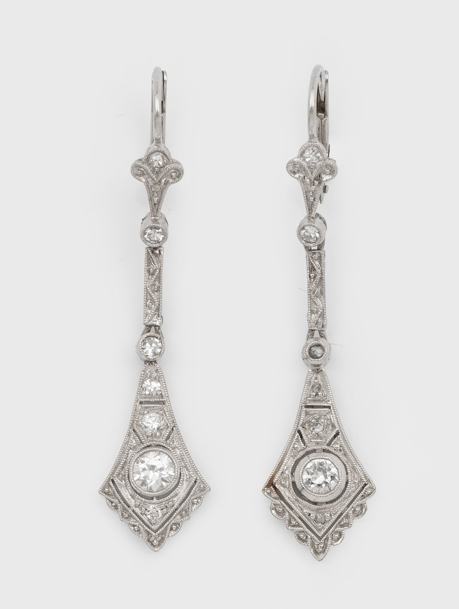 Paar Jugendstil-Diamant-Ohrgehänge in Ajour: Weißgold., 14 ct.; Schauseitig besetzt mit Altschliffdiamanten von zus. ca. 0,30 ct., umzogen von feinen Millgriffbändern. Ges.-Gew. ca. 5,53 g. Pair of earrings set with diamonds approx. 0,30 ct., 
