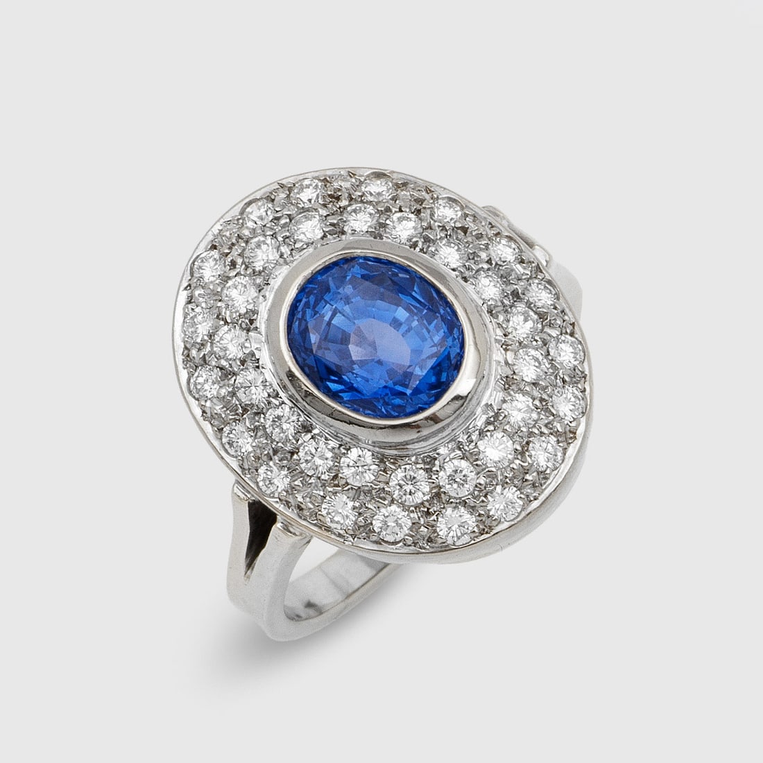 Klassischer Saphir-Brillantring: Weißgold, gest. 585. Zentral besetzt mit einem kornblumenblauen Saphir von ca. 2,00 ct., entouriert von Brillanten von zus. ca. 0,60 ct.; Gew. ca. 7,40 g. Ring set with a cornflower blue sapphire app