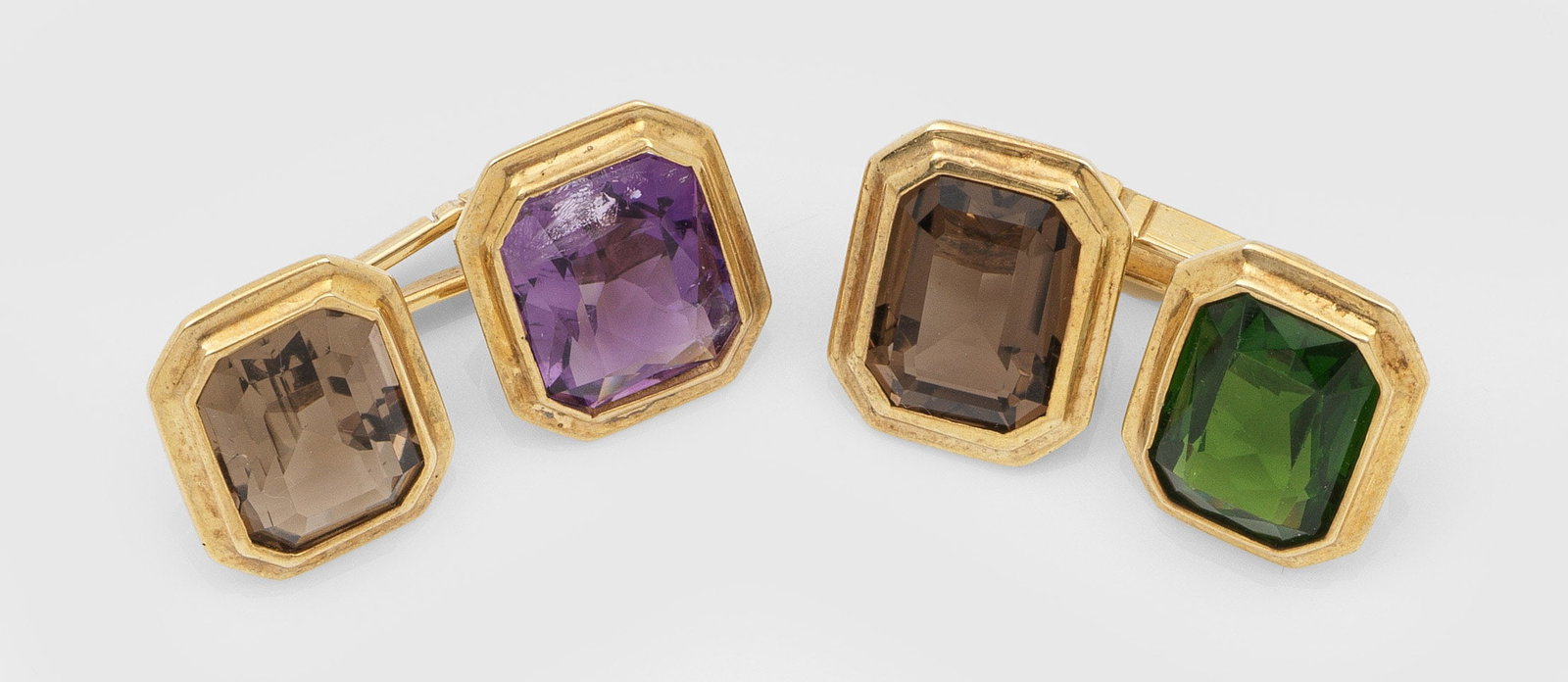 Paar klassische Manschettenknöpfe: Silber, vergoldet, gest. 830/925. Besetzt mit facettierten Steinen in den Farben Grün, Violett und Braun. Ges.-Gew. ca. 8,71 g. Pair of cufflinks set with coloured stones, in silver gilded 830/925.