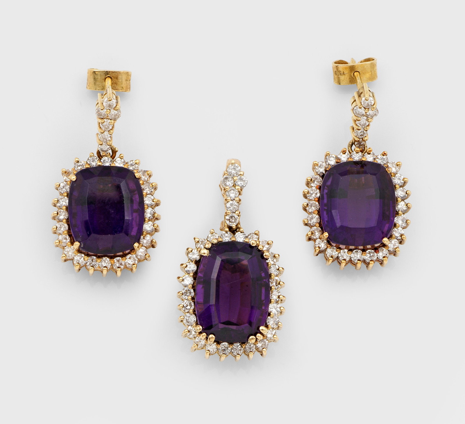 Amethyst-Demi Parure: Gelbgold, gest. 750. Paar Ohrgehänge und korrespondierender Anhänger. Schauseitig besetzt mit tief violetten Amethysten, entouriert von kleinen Diamanten. Ges.-Gew. ca. 16,69 g. Pair of earrings and