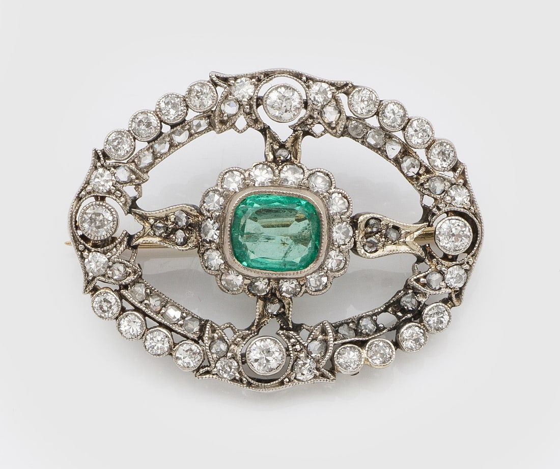Jugendstil-Diamant-Brosche mit Smaragd: Platin. Kranzförmig gestaltet, zentral besetzt mit einem Smaragd von ca. 0,75 ct., ausgefasst mit Altschliffdiamanten von zus. ca. 0,70 ct., umzogen von feinen Millgriffbändern. Gew. ca. 6,06 g. Bro