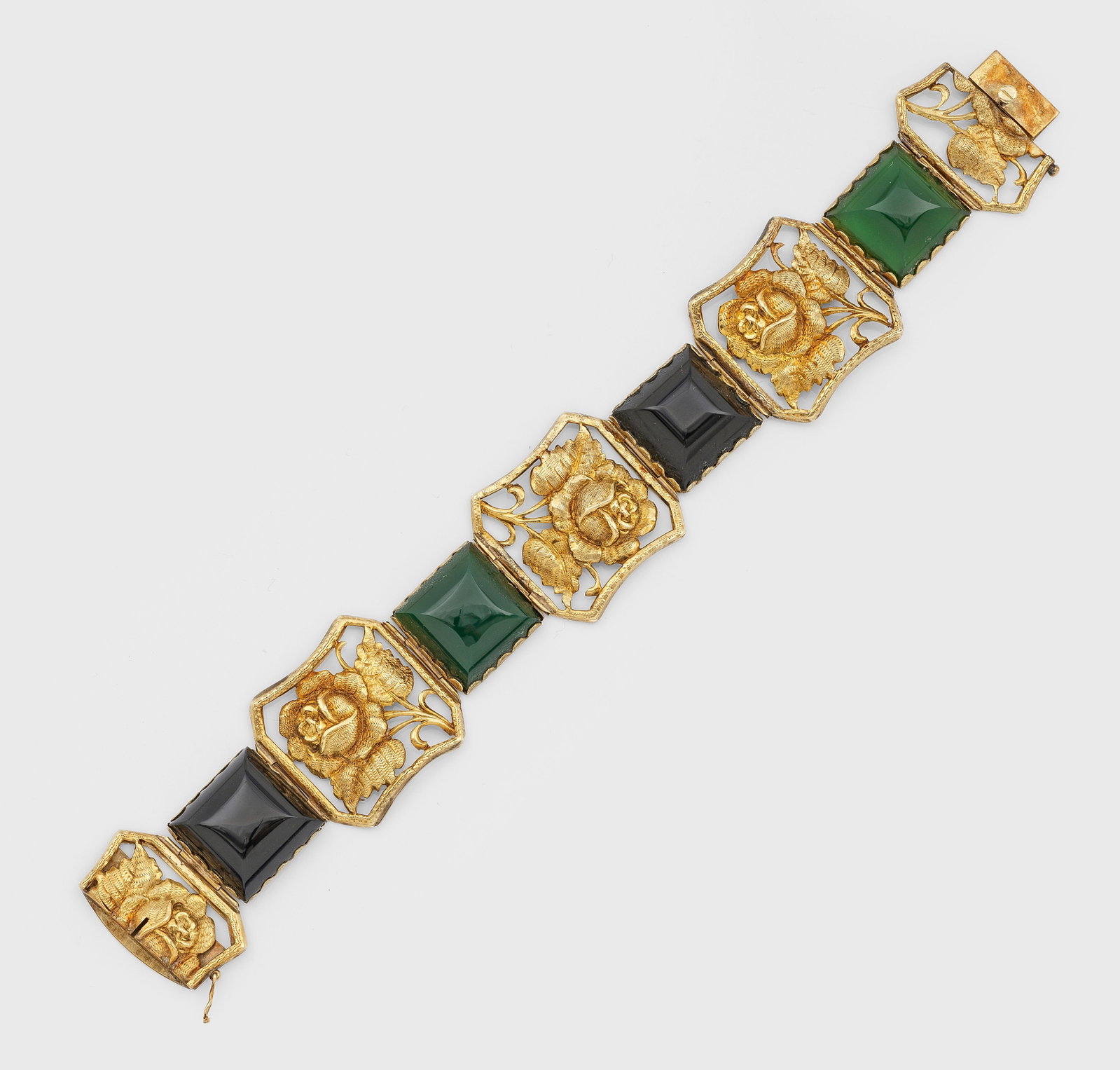 Cocktail-Armband mit Bakelit aus den 1930er Jahren: Silber, vergoldet, gest. 925, französicher Exportstempel. Breite Bandform aus vierpassigen Reserven mit erhabenem Reliefdekor aus Rosenblüten, unterteilt durch farbige Bakelit-Cabochons. Gew. ca. 33