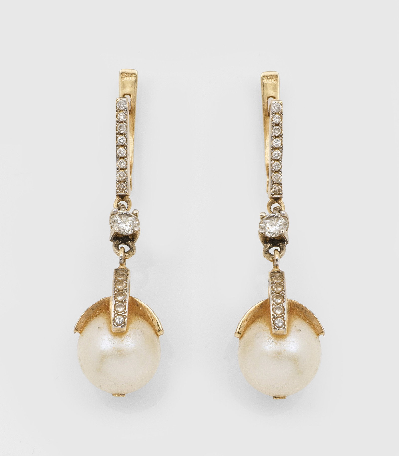 Paar Perl-Brillant-Ohrgehänge: Gelbgold, 14 ct.; Cremefarbene Zuchtperlen von ca. 10,5 mm in sehr feinem, rosé-grün changierendem Lüster, ausgefasst mit Brillanten von zus. ca. 0,60 ct.; Ges.-Gew. ca. 8,50 g. Pair of earrings se
