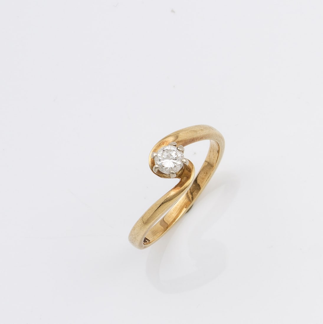 Brillantsolitär-Ring: Gelbgold, gest. 585. Diagonal verlaufende Ringschiene zentral besetzt mit Brillant von ca. 0,20 ct.; Gew. ca. 2,95 g. Ring set with diamond approx. 0,20 ct., in 14 k gold.