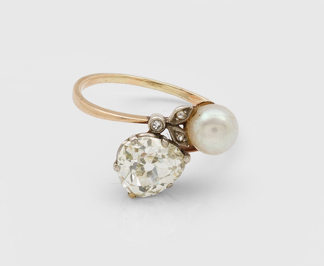 Jugendstil-Toi & Moi-Diamantring mit Perle: Roségold, 14 ct.; Diagonal verlaufende Ringschiene besetzt mit kleiner Perle von ca. 5,6 mm und Diamantrose von ca. 1,50 ct.; Gew. ca. 2,55 g. Ring set with diamond approx. 1,50 ct. and pearl approx.
