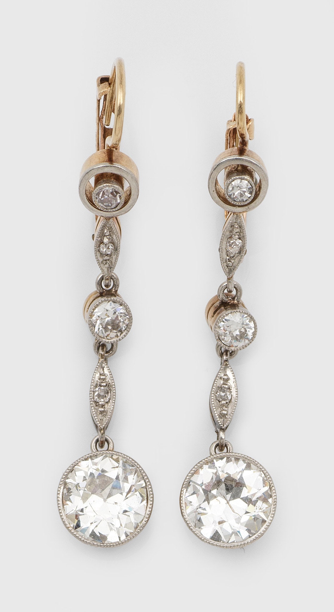 Paar Jugendstil-Diamant-Ohrgehänge: Gelb-Roségold, 14 ct., teilw. mit Silber verbödet. Schauseitig besetzt mit 2 Altschliffdiamanten von zus. ca. 2,00 ct. sowie kleinen korrespondierenden Diamanten von zus. ca. 0,20 ct., umzogen von f