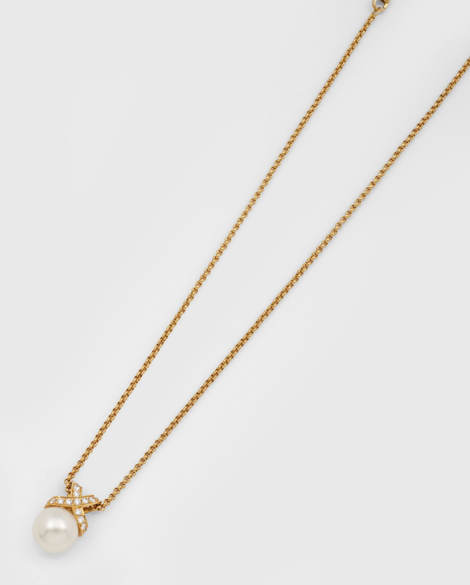 Perl-Brillanthänger mit Chopard-Kette: Gelbgold, gest. 750. Makellose Südsee-Perle von ca. 12,5 mm in sehr farbintensivem, rosé-grün changierendem Lüster, bekrönt von Brillanten von zus. ca. 0,90 ct. (H/vs), an feiner Chopard Erbsen-C