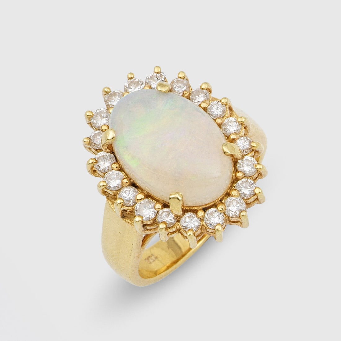 Entourage-Brillantring mit Opal: Gelbgold, gest. 750. Zentral besetzt mit einem Weißopal in sehr feinem Farbspiel, entouriert von Brillanten von zus. ca. 0,40 ct.; Gew. ca. 9,94 g. Ring set with a white opal and diamonds approx. 0,4