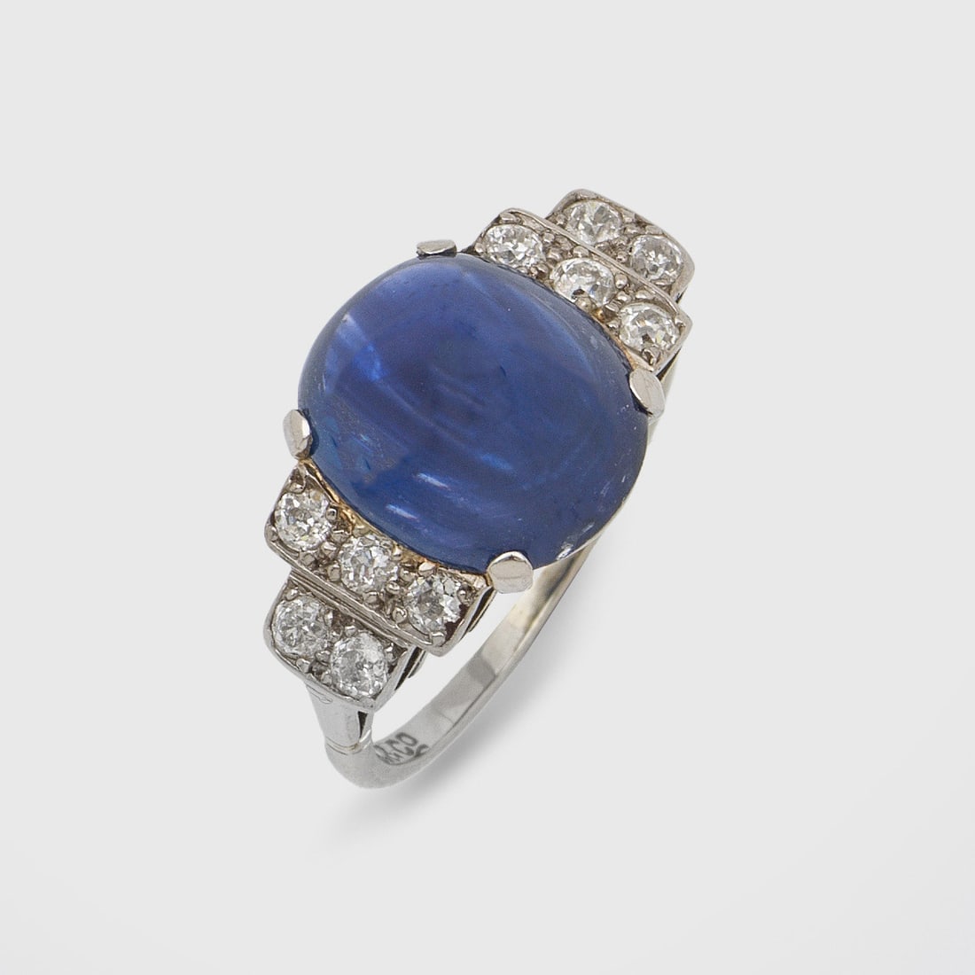 Art Déco-Diamantring: Weißgold und Platin, gest. 18ct./PLAT. Zentral besetzt mit einem tintenblauen Farbsteincabochon, flankiert von Altschliffdiamanten von zus. ca. 0,50 ct.; Gew. ca. 4,17 g. Ring set with a blue stone a
