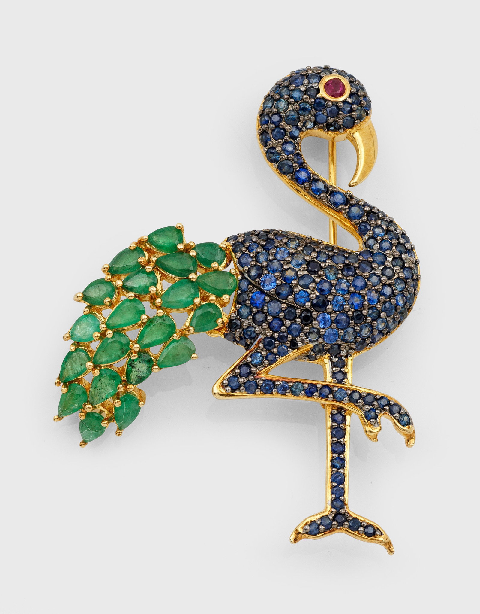 Flamingo-Brosche im Stil von Cartier aus den 1940er Jahren: Silber, vergoldet, gest. 925. Schauseitig besetzt mit Smaragden von zus. ca. 3,98 ct., Saphiren von zus. ca. 3,28 ct. und Rubin von ca. 0,10 ct.; Gew. ca. 11,80 g. Flamingo brooch set with emeralds ap