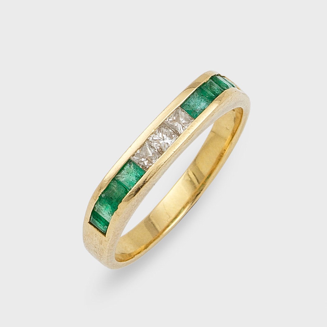 Moderner Bandring mit Smaragden und Diamanten: Gelbgold, gest. 750. Linear besetzt mit Smaragd-Carrées von zus. ca. 0,40 ct. und Diamanten im Princesscut von zus. ca. 0,30 ct.; Gew. ca. 3,54 g. Ring set with emeralds approx. 0,40 ct. and diamonds