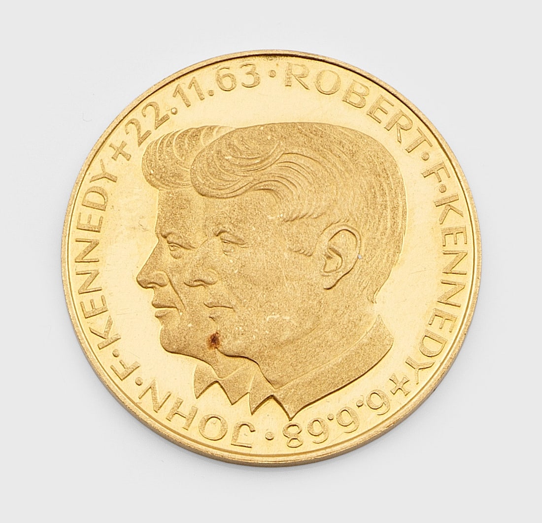 Gedenk-Goldmedaille "J. F. Kennedy, USA 22. Nov. 1963": Feingold, 900. Beidseitiger Schriftzug: "Präsident USA John F. Kennedy" sowie "Wir alle haben ihn verloren 22. Nov. 1963", mit Kreuz. D. 20 mm. Gew. ca. 3,51 g. Memorial coin in 900 gold.