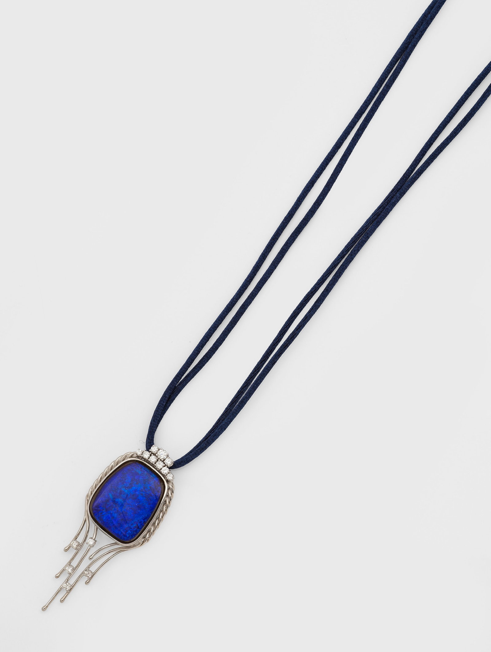Extravaganter Boulder Opal-Brillant-Anhänger: Weißgold, gest. 585. Blau-grüner Opal-Cabochon von sehr feinem Farbspiel, akzentuiert durch Brillanten von zus. ca. 0,80 ct. (G-H/vs), an blauem Seidenband. Gew. ca. 21,24 g. Opale symbolisieren