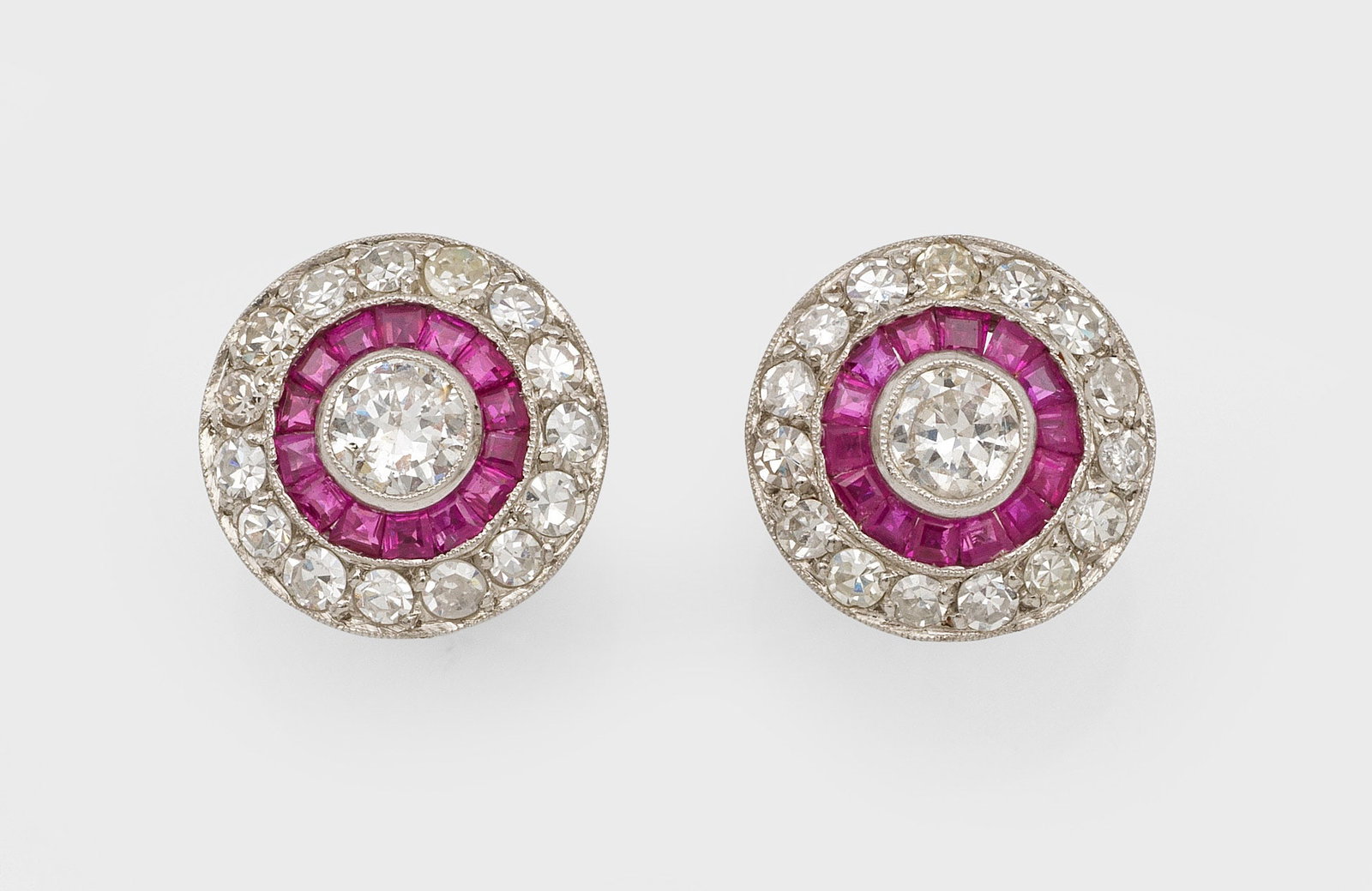 Art Déco Diamant-Rubin-Ohrringe: Weißgold, 18 ct.; Zentral besetzt mit jeweils 2 Altschliffdiamanten von zus. ca. 0,50 ct., entouriert von taubenblutroten Rubincarrées und korrespondierenden Diamanten von zus. ca. 1,60 ct.;