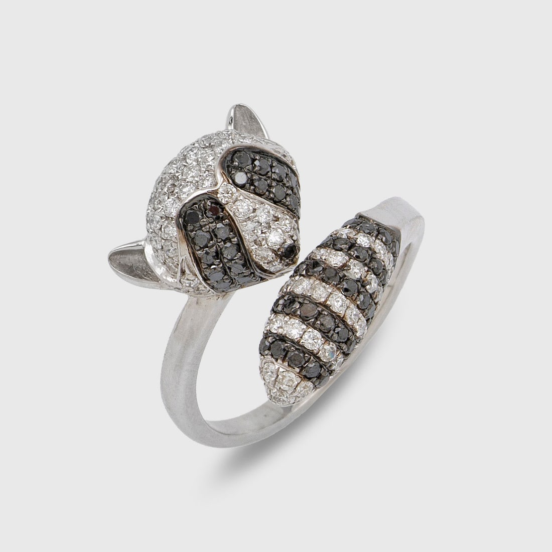 Charmanter Waschbärring mit Diamanten: Weißgold, gest. 750. Plastisch gestaltete Ringschiene, besetzt mit schwarzen und weißen Diamanten von zus. 1,48 ct. (G/vsi) in Pavéfassung. Gew. ca. 7,50 g. Ring set with diamonds approx. 1,48 ct.