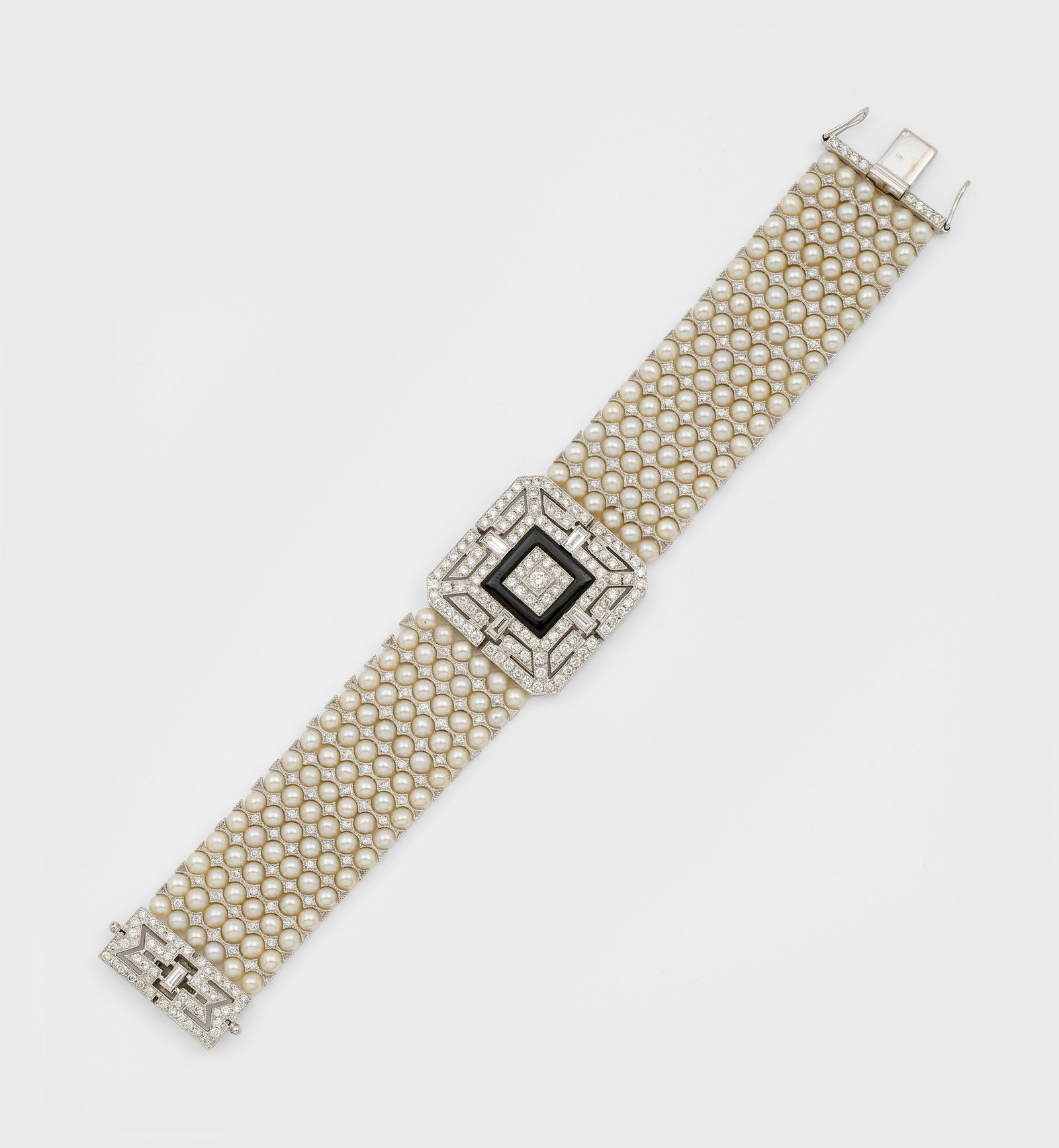 Elegantes Perl-Diamant-Armband im Art Déco-Stil von Cartier: Weißgold, gest. 750. Breite Bandform aus insges. 180 schneeweißen Zuchtperlen im sehr feinem, rosé-grün changierendem Lüster, unterteilt durch kleine Diamanten, zentrales Verbindungs-Ornament in