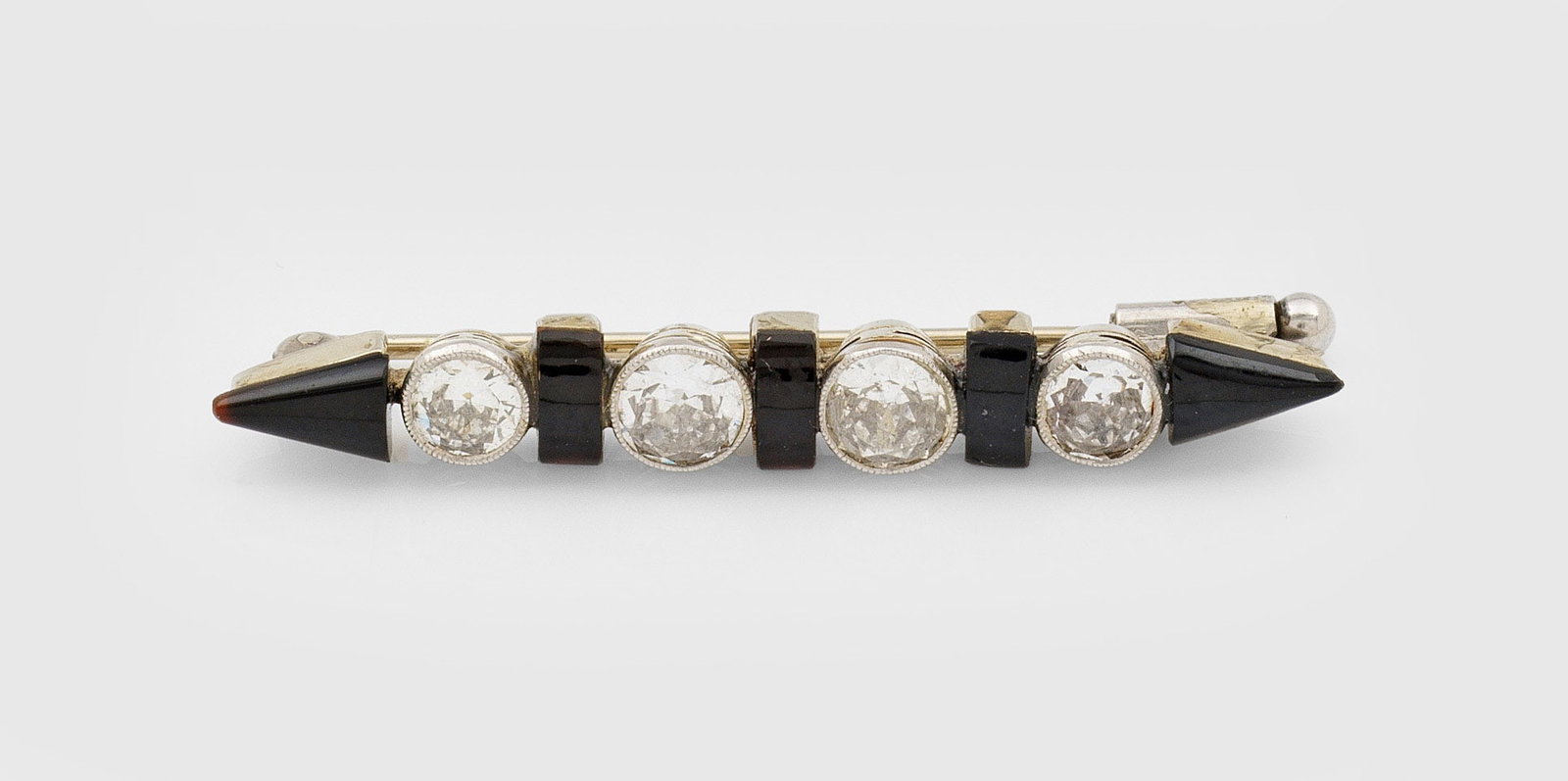 Art Déco-Diamant-Nadel: Platin. Linear besetzt mit Altschliffdiamanten von zus. ca. 0,90 ct., akzentuiert durch schwarze Onyx-Cabochons. Gew. ca. 3,32 g. Needle set with diamonds approx. 0,90 ct. and black onyx, in platinum.