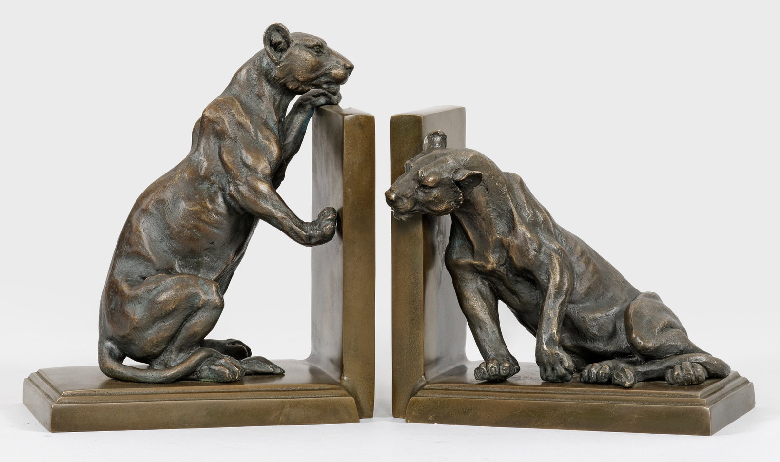 Paar skulpturale Buchstützen im Art Déco-Stil: nach den Vorbildern von Roger Godchaux Gegenstücke. Bronze, patiniert und Messing. Über flachem Sockel vollplastisch gestaltete Panther sich als Buchstützen gegen die Seitenwangen lehnend. Entw. Ro