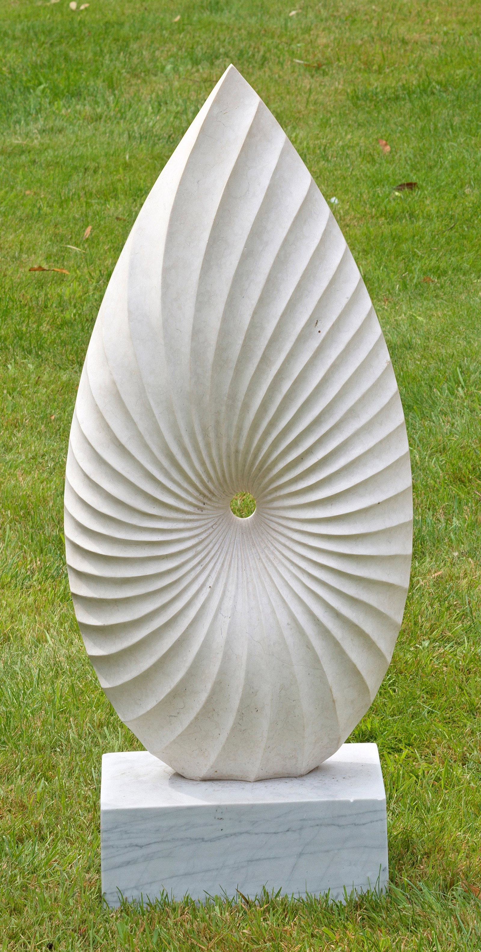 Zeitgenössischer Bildhauer: (Tätig im 20./21. Jh.) Modernes Relief Heller, teilw. gemaserter Marmor. Auf Rechecksplinte mandelförmig spitz zulaufende, vorderseitig muschelförmig vertiefter und konturierter, rücks. glatter Ko