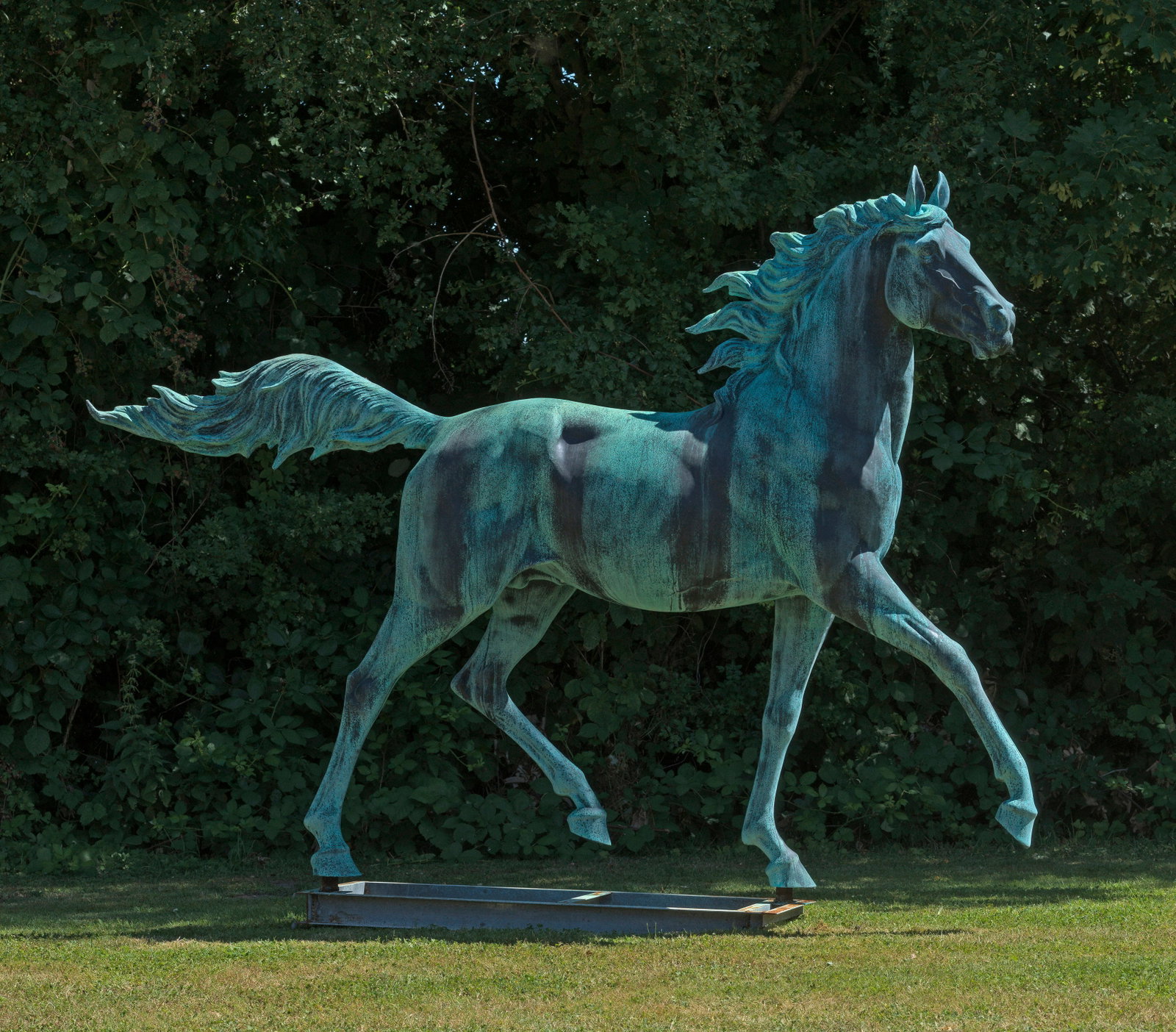 Zeitgenössischer Tierbildhauer: (Tätig im 21. Jh.) Trabender Hengst Bronze, in graugrünen und dunklen Tönen patiniert sowie mit gewachsener Patina; montiert auf einem rechteckigen Stahlgerüst mit Rostpatina. Vollplastische, monu