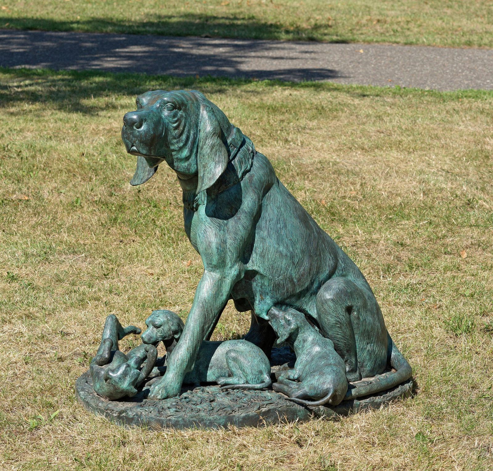 Prosper Lecourtier: (1855 Gremilly - 1924 Paris) nach Sitzender Hund mit Welpen Bronze, dunkel und grün patiniert. Auf ovalem Sockel vollplastische szenische Darstellung eines sitzenden Bluthundes, seiner drei unterhalb