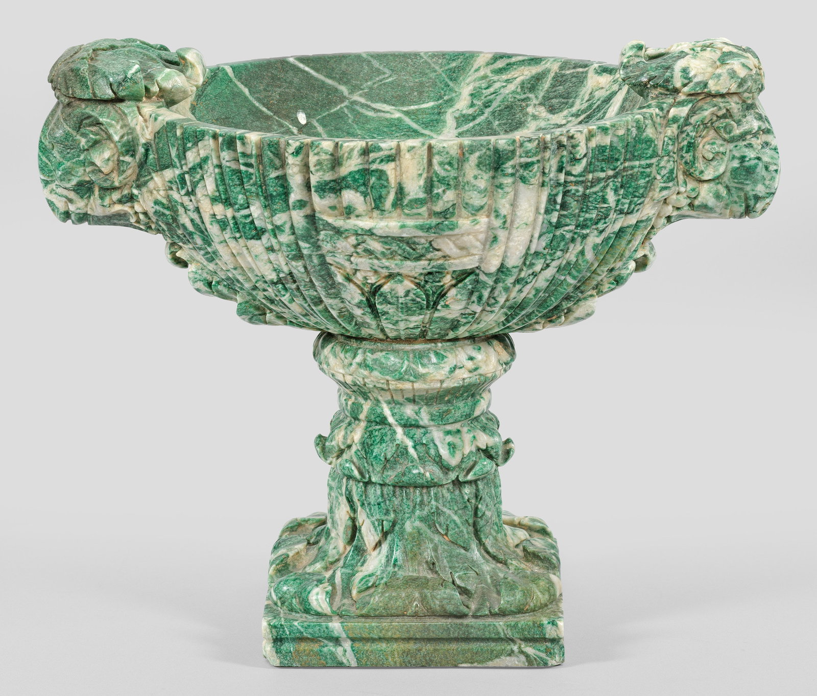 Prächtige Marmor-Tazza im Empire-Stil: Überwiegend in kräftigem Grün und mattweiß gemaserter Marmor. Über profilierter Rechtecksplinthe aufsteigender blattrelfierter Schaft in Eierstabbordüre endend als Träger für die oval geformte