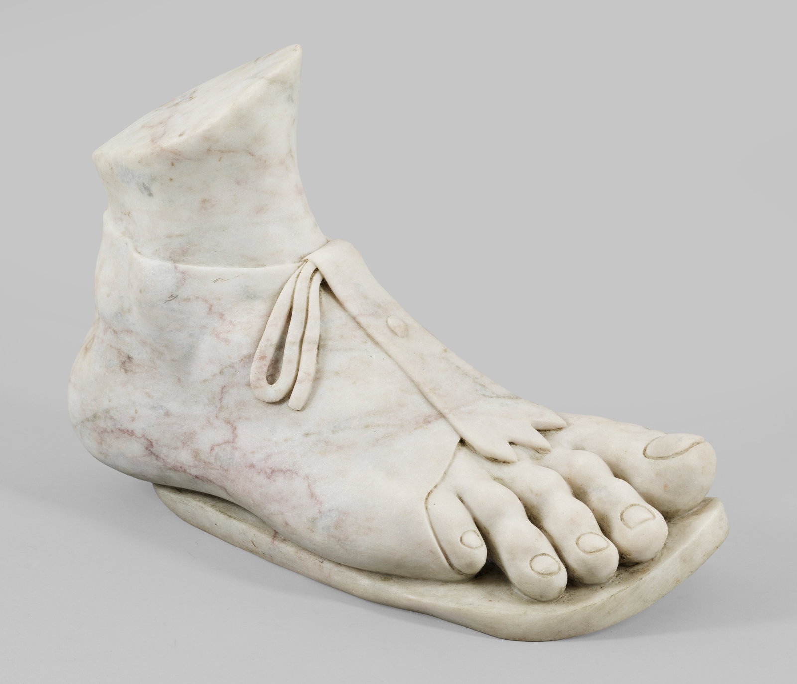 Römischer Fuß nach antikem Vorbild: Heller Marmor. Fragment in Form eines vollplastisch ausgeführten rechten Füßes in einer Solea mit sichtbaren Zehen. Ursprünglich zu einer antiken römischen Statuette gehörend, befindet sich ein 
