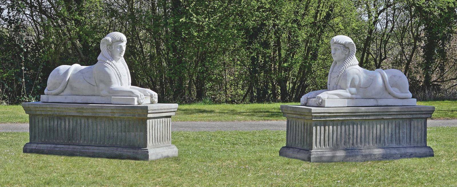 Paar Sphingen: Gegenstücke. Weißer, leicht hellgrau geäderter Marmor. Repräsentative, neoklassizistische Park- bzw. Gartenskulpturen. Auf rechteckigen, vorne abgesetzten Plinthen ruhende, vollplastisch ausgefüh