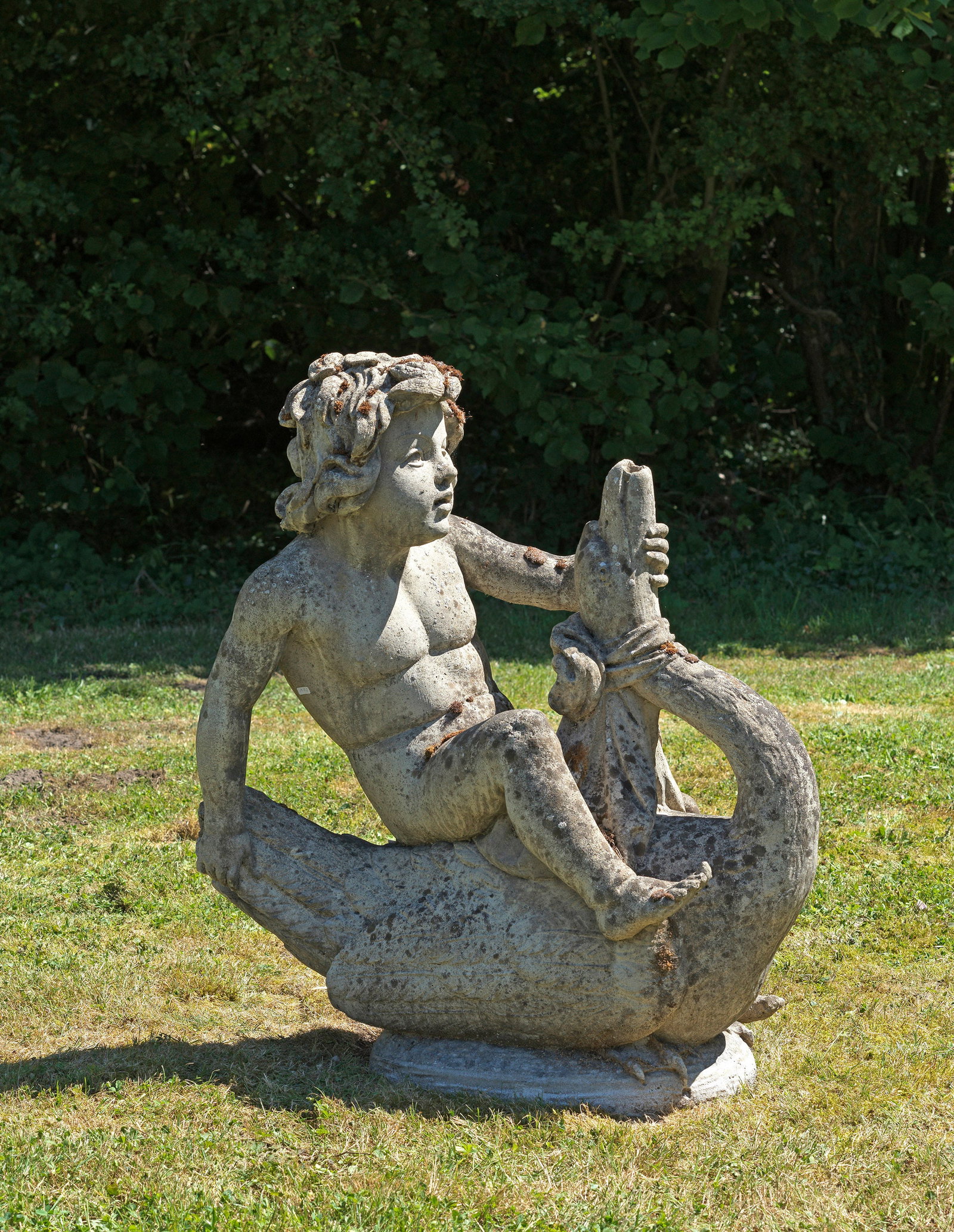 Brunnenfigur im Louis-XVI-Stil: Steinguss. Auf ovalem Sockel die vollplastische Darstellung eines Schwan reitenden Puttos, sich am Hals und Gefieder festhaltend. Altersspuren. H. 90 cm. A Louis XVI-style stone cast fountain figure. 