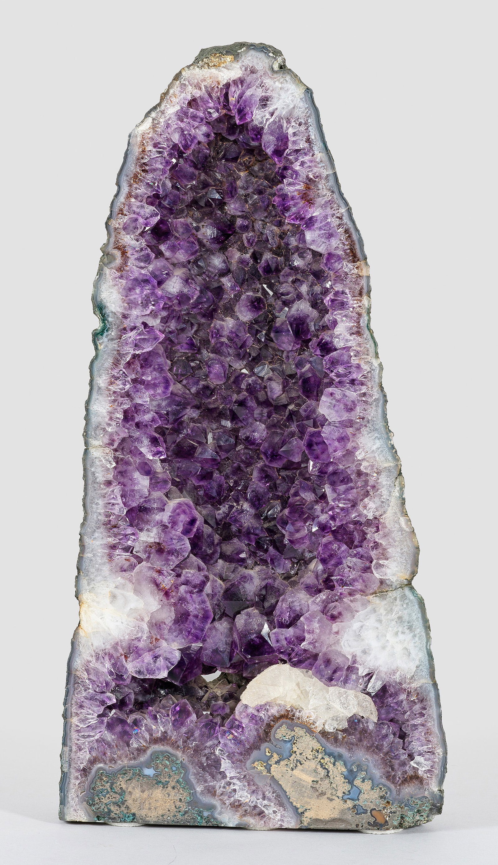 Große Amethystdruse: Umgeben von Chalcedonkruste fliederfarbene bis violette Amethystkristalle, schauseitig mit glatter, polierter Schnittkante. Rest.; Gew. ca. 7650 g. H. 44 cm. 21,5 x 9,5 cm. A South American tall ameth