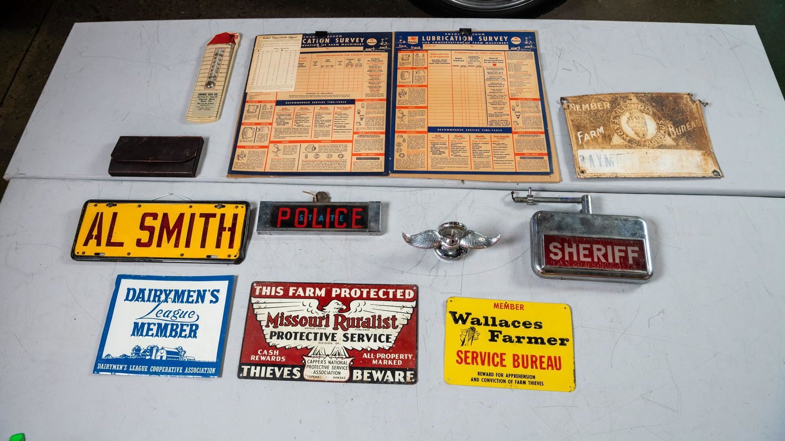 Assorted Automotive, Farming, and Police Memorabilia: Lot T612 - Assorted Automotive, Farming, and Police Memorabilia HIGHLIGHTS Grange Silo Co. Thermometer 2 Mobiloil Lubcration Surveys, 30x18 Illinois Farm Bureau Tin Sign Central Petroleum Co. Salesman